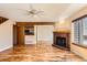 Open living room showcasing hardwood floors, brick fireplace, and seamless transition to the kitchen area at 8040 Holland Ct # C, Arvada, CO 80005