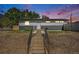 Charming one-story home with a gray and white exterior and a well-maintained yard, set against a colorful sky at 7450 Granada Rd, Denver, CO 80221
