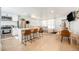 Open concept living space with modern kitchen island, comfortable seating, and dining area, all bathed in natural light at 7450 Granada Rd, Denver, CO 80221