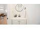 Clean powder room featuring a modern vanity, a round mirror, and sleek fixtures with neutral decor at 7450 Granada Rd, Denver, CO 80221