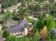 Aerial view of the property showcasing the landscaping, pond, home, and surrounding trees at 10145 Meadow Run, Parker, CO 80134