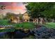 Backyard view with pond, landscaping, mature trees, outdoor lighting and backyard structure at 10145 Meadow Run, Parker, CO 80134