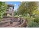 Stone backyard patio with firepit and lush landscaping, perfect for outdoor relaxation and entertaining at 10145 Meadow Run, Parker, CO 80134