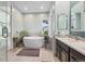 Bright bathroom with a modern soaking tub, double vanity, and elegant tile work at 10145 Meadow Run, Parker, CO 80134