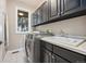 Laundry room with modern washer and dryer, utility sink, and ample cabinet space at 10145 Meadow Run, Parker, CO 80134