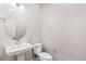 Elegant powder room featuring a pedestal sink and oval mirror at 21097 E 62Nd Dr, Aurora, CO 80019