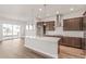 Modern kitchen with a large island, stainless steel appliances, and a seamless flow to the living area at 21097 E 62Nd Dr, Aurora, CO 80019