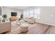 Bright living room with hardwood floors, large windows, and stylish neutral furniture at 21097 E 62Nd Dr, Aurora, CO 80019