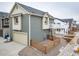 New construction gray home boasting a two-car garage, charming fenced yard, and modern architectural details at 46538 Avery Ln, Bennett, CO 80022
