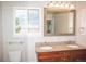 Elegant bathroom featuring a double vanity with granite countertops and a large window with a scenic view at 10554 Tanglewood Rd, Franktown, CO 80116