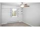 Neutral bedroom with light carpet, a ceiling fan, shelving, and a large window with outdoor views at 10554 Tanglewood Rd, Franktown, CO 80116