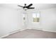 Bright bedroom featuring neutral walls, carpet, a ceiling fan, and two windows framing pleasant outdoor views at 10554 Tanglewood Rd, Franktown, CO 80116