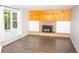 Cozy living room with a brick fireplace, wood paneling, and ample natural light from large windows at 10554 Tanglewood Rd, Franktown, CO 80116