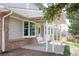 Inviting covered patio with comfortable porch swing, brick accents, and a relaxing outdoor space at 10554 Tanglewood Rd, Franktown, CO 80116