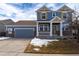 Charming two-story home with a covered porch, stone accents, and a two-car garage at 15415 Carob Cir, Parker, CO 80134