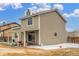 An exterior backyard view features a two-story home with a covered patio and wintery lawn at 7768 Xavier Ct, Westminster, CO 80030