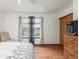 Bright bedroom with wood-look floors, ceiling fan, and a view from the large window at 7768 Xavier Ct, Westminster, CO 80030