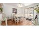 Bright dining room with a white table, striped chairs, wood floors, and a sliding door to the patio at 7768 Xavier Ct, Westminster, CO 80030