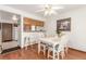 Bright dining room with a white table, striped chairs, and wood floors, open to the kitchen area at 7768 Xavier Ct, Westminster, CO 80030