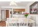 Bright dining room with a white table and chairs, and wood floors, open to the kitchen area at 7768 Xavier Ct, Westminster, CO 80030
