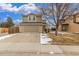 Inviting two-story home featuring a two-car garage and a well-maintained front yard with a touch of winter snow at 7768 Xavier Ct, Westminster, CO 80030