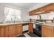 Functional kitchen with wood cabinets, laminate countertops, white appliances, and a window over the sink at 7768 Xavier Ct, Westminster, CO 80030