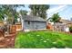 A spacious backyard with a lush lawn, greenhouse, and a charming garden shed at 1548 Ulster St, Denver, CO 80220