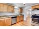 Kitchen featuring wood cabinets, granite countertops, and stainless steel appliances at 1548 Ulster St, Denver, CO 80220