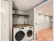 Laundry room featuring front load washer and dryer, shelving, and wood countertop at 1548 Ulster St, Denver, CO 80220