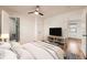 Comfortable primary bedroom with hardwood floors, a modern fan and en-suite bath at 1548 Ulster St, Denver, CO 80220