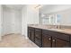 Bathroom with granite countertops, double sinks, a large mirror and tiled floor, showcasing elegance at 1356 Castle Creek Cir, Castle Rock, CO 80104