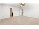 Spacious bedroom with neutral carpet and ceiling fan, featuring doorways to bathroom and upper level at 1356 Castle Creek Cir, Castle Rock, CO 80104