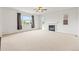 A large living room featuring a fireplace, neutral carpet, and a ceiling fan at 1356 Castle Creek Cir, Castle Rock, CO 80104