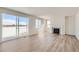 Open-concept living room with a fireplace, large windows and light wood floors at 14155 Bunny Hop Ln, Parker, CO 80134