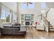 Open living room with large windows, a fireplace, and a staircase leading to the second floor at 7565 S Quantock Ct, Aurora, CO 80016