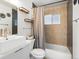 Modern bathroom featuring a sleek sink, floating shelves, and a tiled shower with a window at 7669 Pecos St, Denver, CO 80221