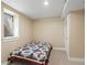 Bedroom with carpet, window, door, and a bed with geometric patterned quilt and neutral walls at 7669 Pecos St, Denver, CO 80221