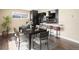 Modern dining area with sleek table set, stylish chairs and bar stool seating at the kitchen island at 7669 Pecos St, Denver, CO 80221
