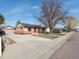 Charming single-story brick home with a spacious front yard and mature trees on a sunny day at 7669 Pecos St, Denver, CO 80221