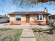 Charming single-story brick home with solar panels and a well-manicured front yard on a sunny day at 7669 Pecos St, Denver, CO 80221