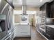 Open kitchen with white island, stainless steel refrigerator, and view into the dining room at 7669 Pecos St, Denver, CO 80221