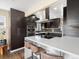 Modern kitchen boasts stainless steel appliances, a white island with seating, and stylish fixtures at 7669 Pecos St, Denver, CO 80221