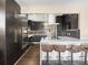 Modern kitchen features a sleek white island with bar stool seating and black cabinetry at 7669 Pecos St, Denver, CO 80221