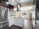 Bright kitchen with white island, stainless steel refrigerator, and modern light fixture at 7669 Pecos St, Denver, CO 80221