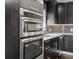 Dark, modern kitchen featuring stainless appliances and quartz countertops at 7669 Pecos St, Denver, CO 80221