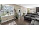 A spacious living room featuring a large window, plants, hardwood floors and comfortable seating at 7669 Pecos St, Denver, CO 80221
