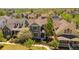 Aerial view of a gray two-story home with landscaping, a picket fence, and nestled among lush greenery in a neighborhood at 2924 Fulton St, Denver, CO 80238