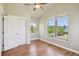 Cozy bedroom featuring wood floors, a ceiling fan, and natural light from the windows at 2924 Fulton St, Denver, CO 80238