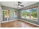 Bright bedroom featuring hardwood floors, three large windows, and neutral paint colors at 2924 Fulton St, Denver, CO 80238