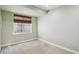This bedroom features a window with a horizontal blind and neutral carpeting at 2924 Fulton St, Denver, CO 80238